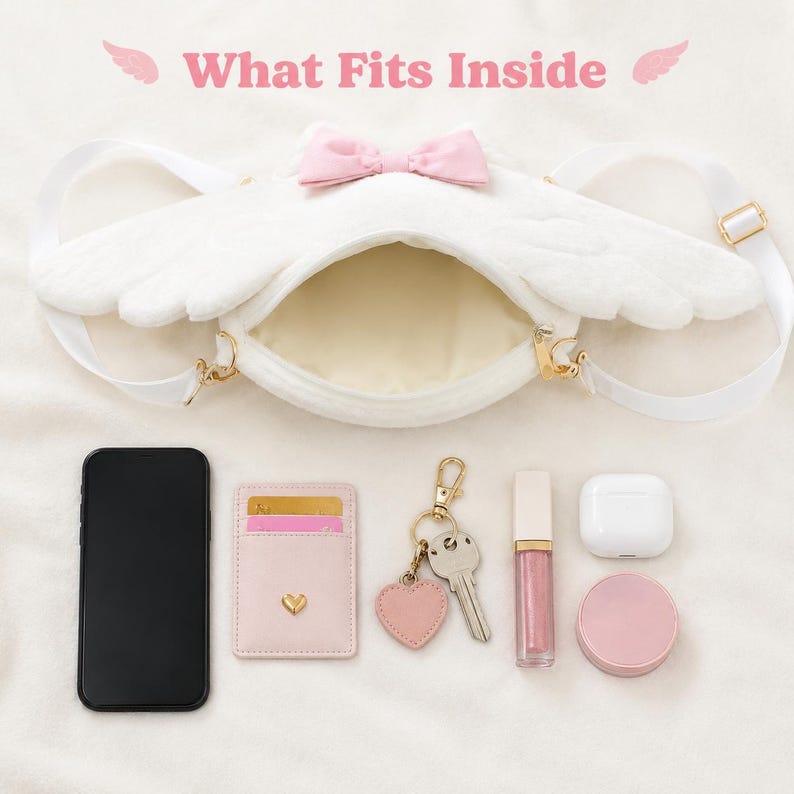 May include: White plush crossbody bag shaped like angel wings, with a pink bow and gold hardware. The bag is open, revealing its interior. Items inside include a phone, cardholder, keys, lip gloss, earbuds, and a compact.