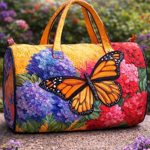 May include: A quilted tote bag featuring a large orange and black butterfly applique. The bag is decorated with colorful floral patterns, including blue, purple, and red hydrangeas. It has yellow handles and a matching yellow top.