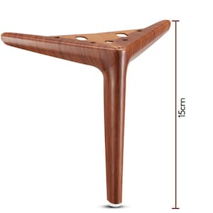 Puede incluir: Una pata de mueble con acabado de veta de madera marrón y una placa de montaje triangular con tres orificios circulares para tornillos. La pata tiene una forma cilíndrica cónica y mide 15cm de altura, según la línea de medición vertical.