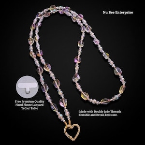 Könnte beinhalten: Eine Handykette mit irisierenden, facettierten Perlen und einem goldfarbenen Herzanhänger. Die Kette ist aus doppeltem Jadefaden gefertigt und enthält eine Halterung. Der Text auf dem Bild lautet "Nu Bee Enterprise".
