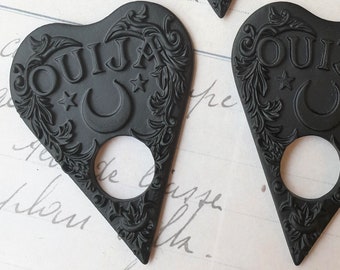 May include: Three black heart-shaped Ouija planchette charms with a crescent moon and stars design.