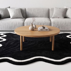 Modern zwart onregelmatig golvend tapijt met witte rand, zacht pluche, eigentijds luxe vloertapijt.