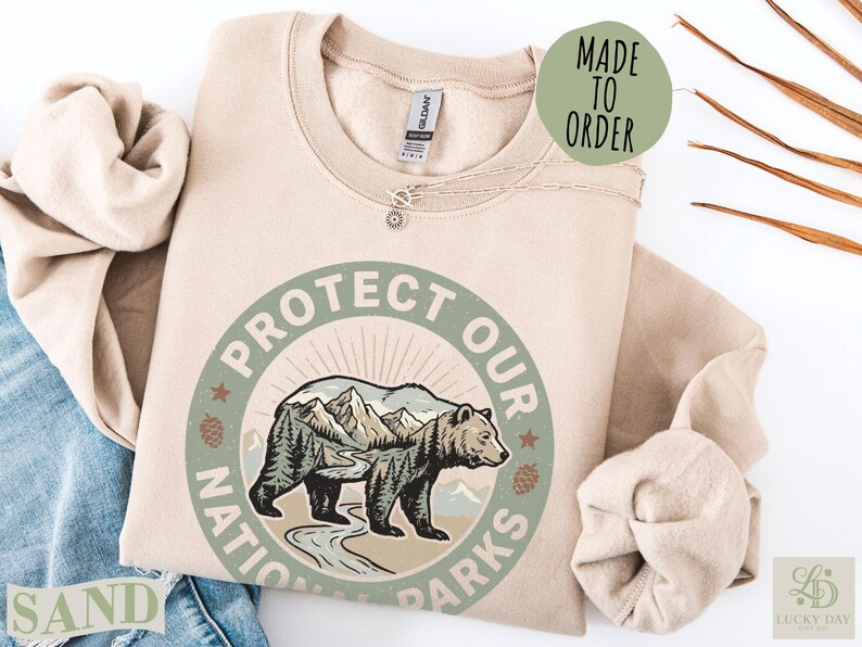 Sand colored sweatshirt with "Protect Our National Parks" circular graphic.