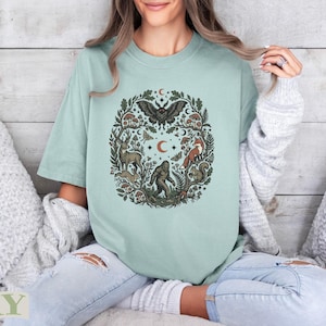 Green t-shirt with a circular forest animal and nature design.