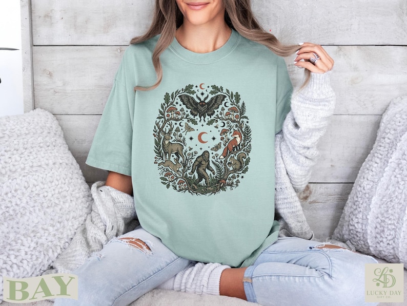 Green t-shirt with a circular forest animal and nature design.