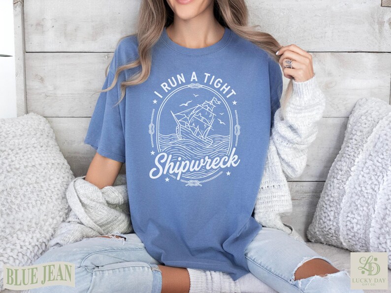 Blue t-shirt with "I Run a Tight Shipwreck" text and sailing ship graphic.