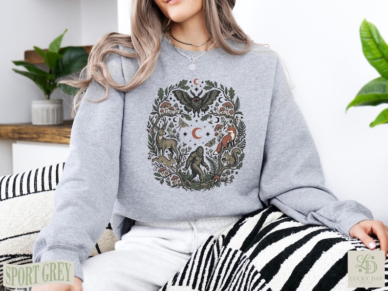 Grey crewneck sweatshirt with forest animal and moth graphic design.