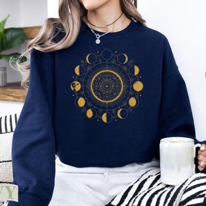 Navy sweatshirt with celestial moon phase and mandala design.