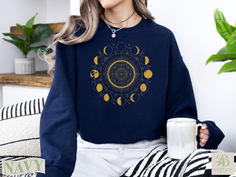 Navy sweatshirt with celestial moon phase and mandala design.
