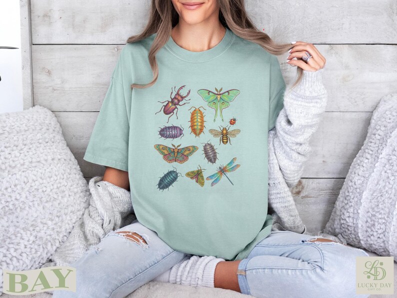 T-shirt with colorful botanical illustrations of various insects, including beetles, moths, and dragonflies.
