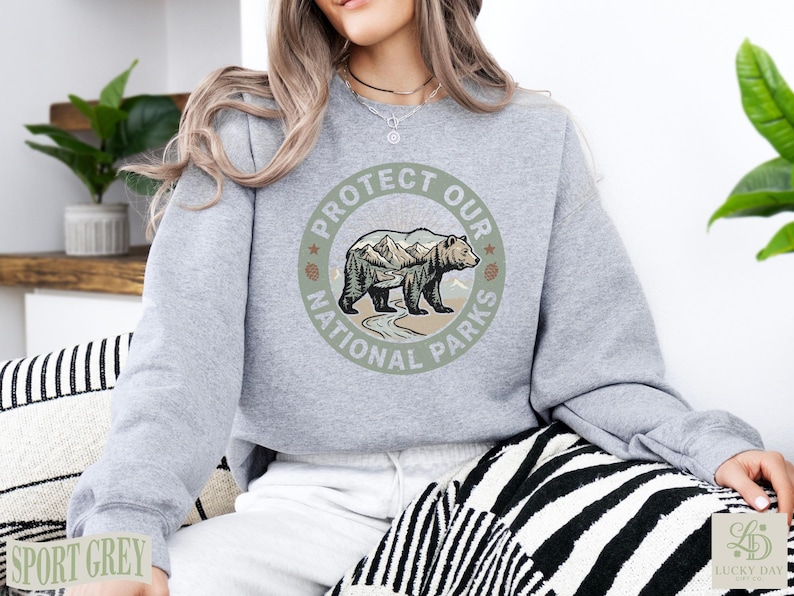 Grey sweatshirt with "Protect Our National Parks" graphic featuring a bear and mountains.