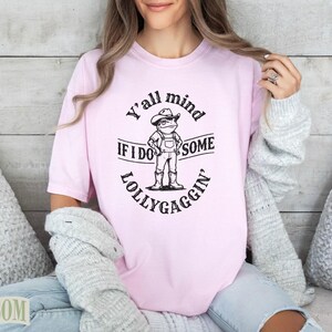 Pink t-shirt with "Y'all mind IF I DO SOME LOLLYGAGGIN'" text and frog graphic.