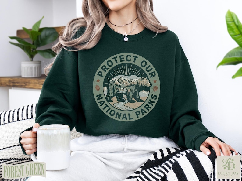 Dark green sweatshirt with "Protect Our National Parks" bear graphic.