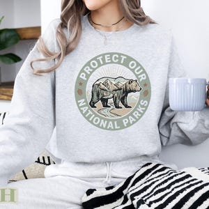 Light grey sweatshirt with "Protect Our National Parks" circular graphic featuring a bear.