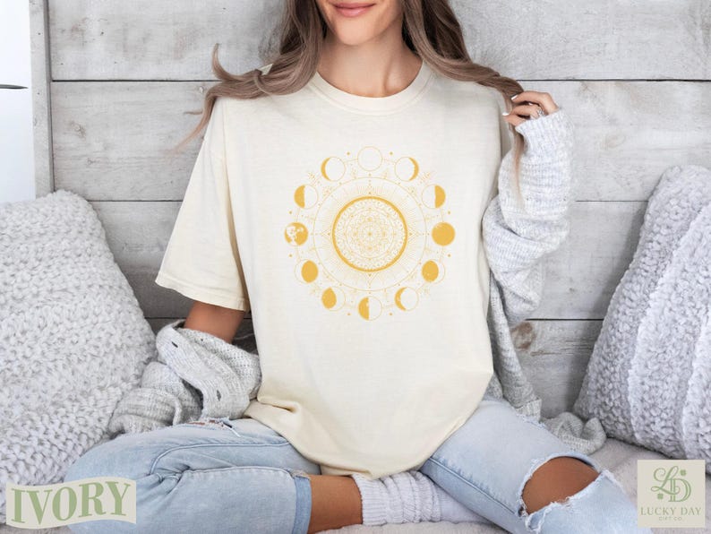 Cream t-shirt with yellow moon phases mandala design, woman wearing shirt.