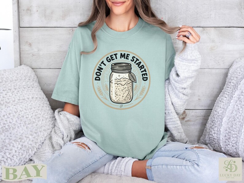 Light mint graphic tee with sourdough jar design and "Don't Get Me Started" text.