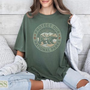 Green t-shirt with "Protect Our National Parks" text and bear illustration.