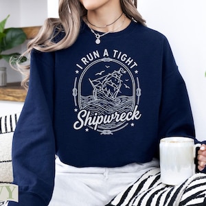 Navy sweatshirt with "I Run A Tight Shipwreck" nautical ship graphic.