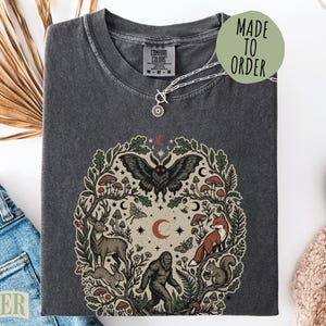 Black t-shirt with mystical forest animal graphic and "Made to Order" text.