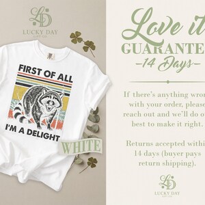 White t-shirt with raccoon graphic and "I'M A DELIGHT" text.