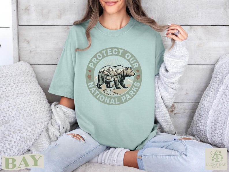 Bear and mountains design on light green t-shirt with "Protect Our National Parks" text.