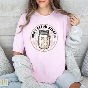 Pink t-shirt with "Don't Get Me Started" text and a mason jar graphic.