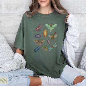 Green t-shirt with colorful insect illustrations and "Moss" text.