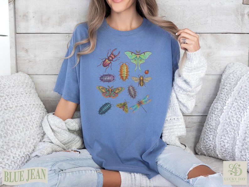 Blue t-shirt with colorful illustrations of insects: beetle, moth, bee, dragonfly.