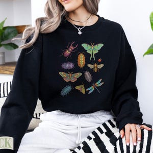 Black sweatshirt with various illustrated insects including a beetle, moth, and dragonfly.