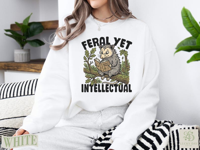 Opossum reading a book with "FERAL YET INTELLECTUAL" text.