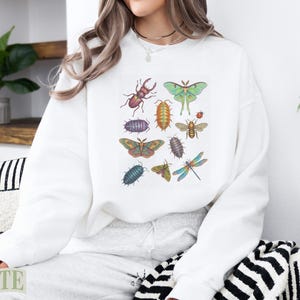 White sweatshirt with a colorful collection of illustrated insects and bugs.