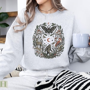 Light grey sweatshirt with woodland creatures and celestial elements design.