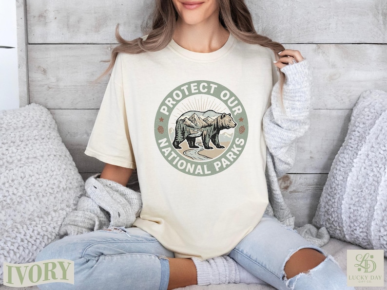 Cream t-shirt with "Protect Our National Parks" circular bear and mountain graphic.