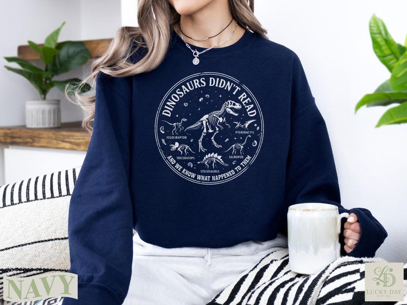 Navy sweatshirt with dinosaur graphic and text "Dinosaurs Didn't Read".