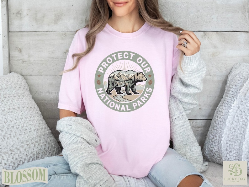 Pink t-shirt with circular "Protect Our National Parks" graphic featuring a bear and mountains.
