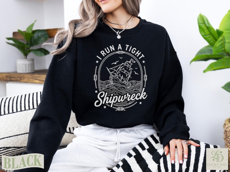 Black crewneck sweatshirt with "I Run A Tight Shipwreck" graphic.