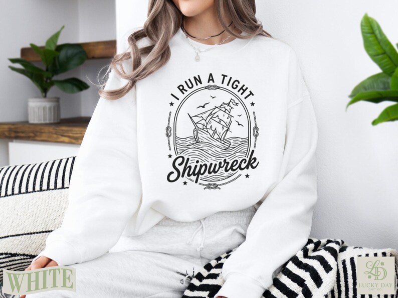 White sweatshirt with a circular graphic of a sailing ship in a storm.
