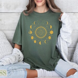 Green t-shirt with gold moon phases and mandala design.