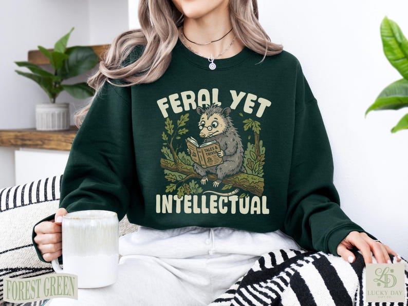 Opossum reading a book on a branch, "Feral Yet Intellectual" text.
