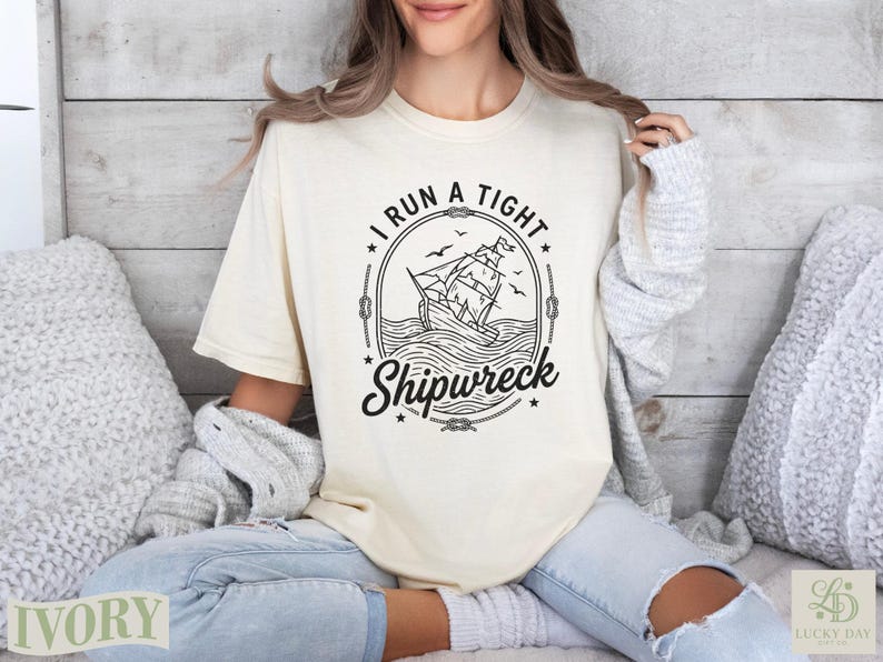 Cream t-shirt with "I run a tight Shipwreck" text and ship illustration.
