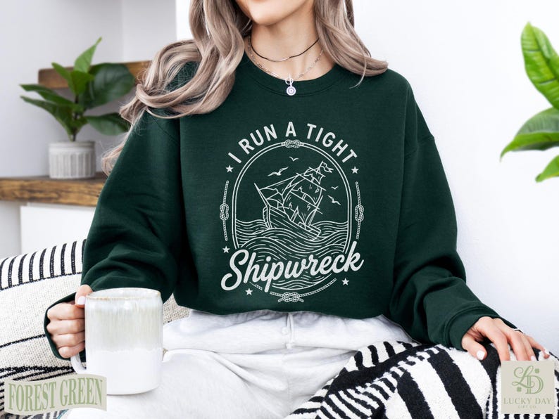 Dark green sweatshirt with "I RUN A TIGHT SHIPWRECK" nautical graphic.