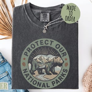 Dark gray t-shirt with "Protect Our National Parks" text and bear graphic.
