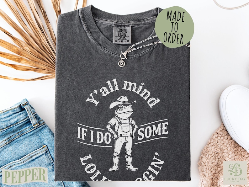 Dark gray Comfort Colors t-shirt with frog wearing cowboy hat and "Y'all mind if I do some lolly gin'" text.