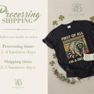 Black t-shirt with raccoon graphic and text "First of all, I'm a deli black".