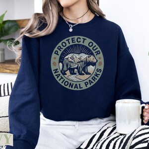 Navy sweatshirt with "Protect Our National Parks" circular graphic featuring a bear.