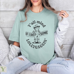 Light green t-shirt with frog illustration and text "Y'all mind if I do some lollygaggin'".