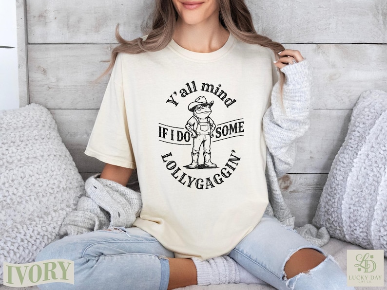 Cream t-shirt with frog graphic and "Y'all mind if I do some lollygaggin'" text.