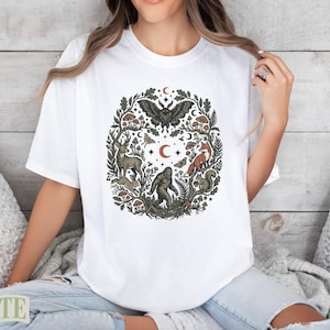 White t-shirt with circular woodland creature and nature design.