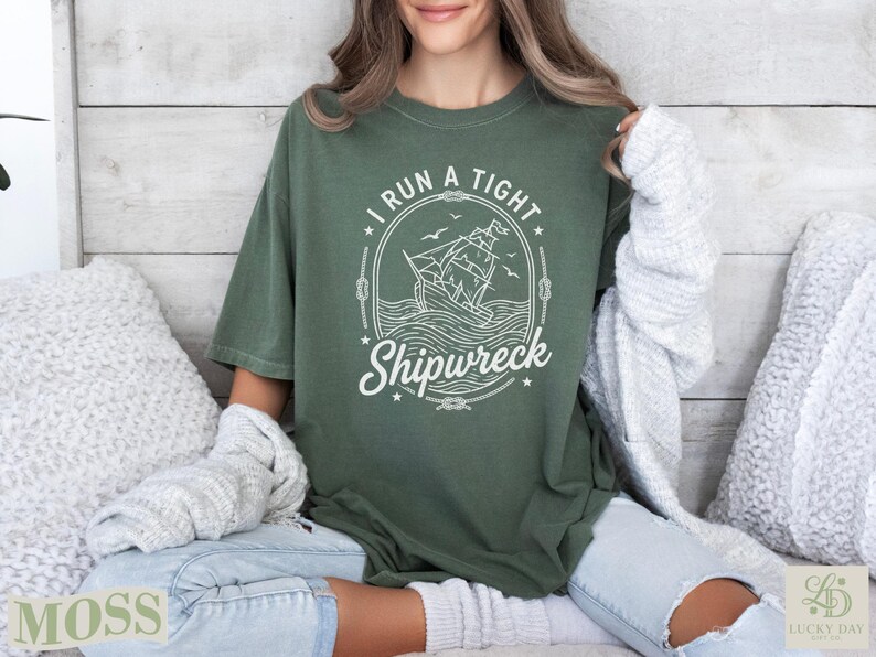 Green t-shirt with a ship and "I RUN A TIGHT SHIPWRECK" graphic.
