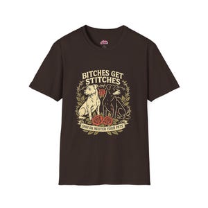 May include: A brown t-shirt featuring a graphic with two dogs, one cream-colored and one black, surrounded by roses and thorns. The text reads "BITCHES GET STITCHES" above and "SPAY OR NEUTER YOUR PETS" below the dogs.